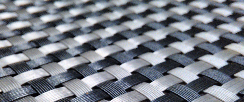 Close-up of a black and white woven pattern, resembling interlaced synthetic fibers or a basket weave.