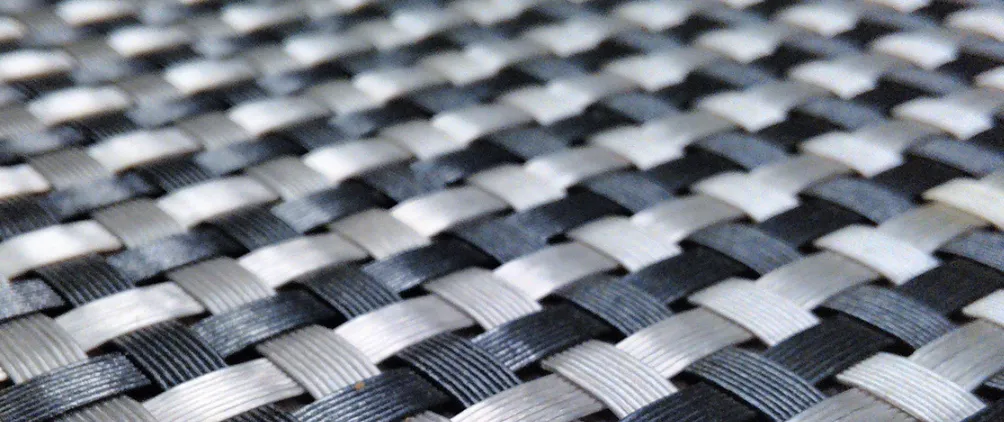 Close-up of a black and white woven pattern, resembling interlaced synthetic fibers or a basket weave.